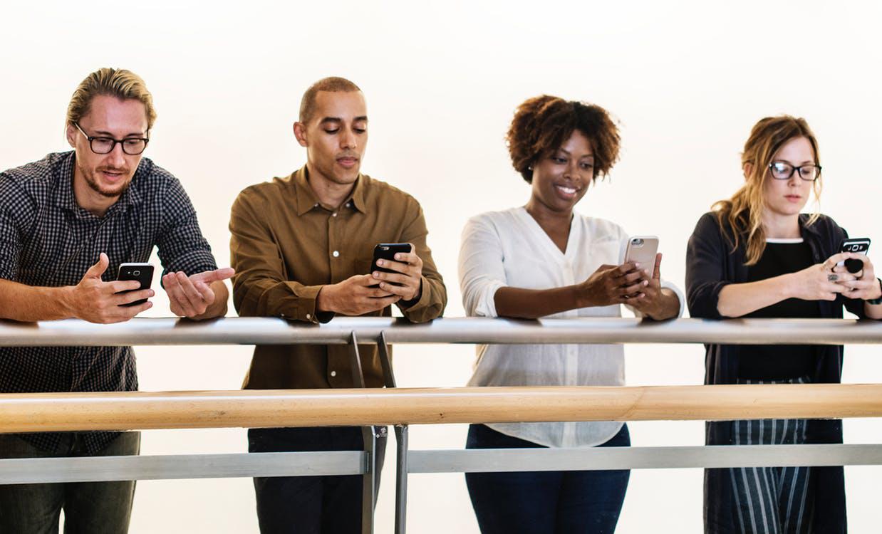 Input Image of four people looking at phones